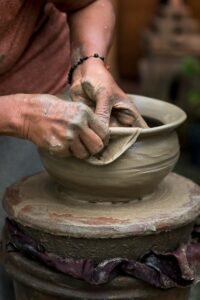 A skilled potter shaping clay on a wheel, showcasing traditional craftsmanship and creativity.