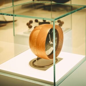 An elegant wooden clock encased in glass, blending modern and vintage design elements.