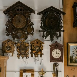 A collection of vintage cuckoo clocks mounted on a wooden wall, showcasing intricate designs.